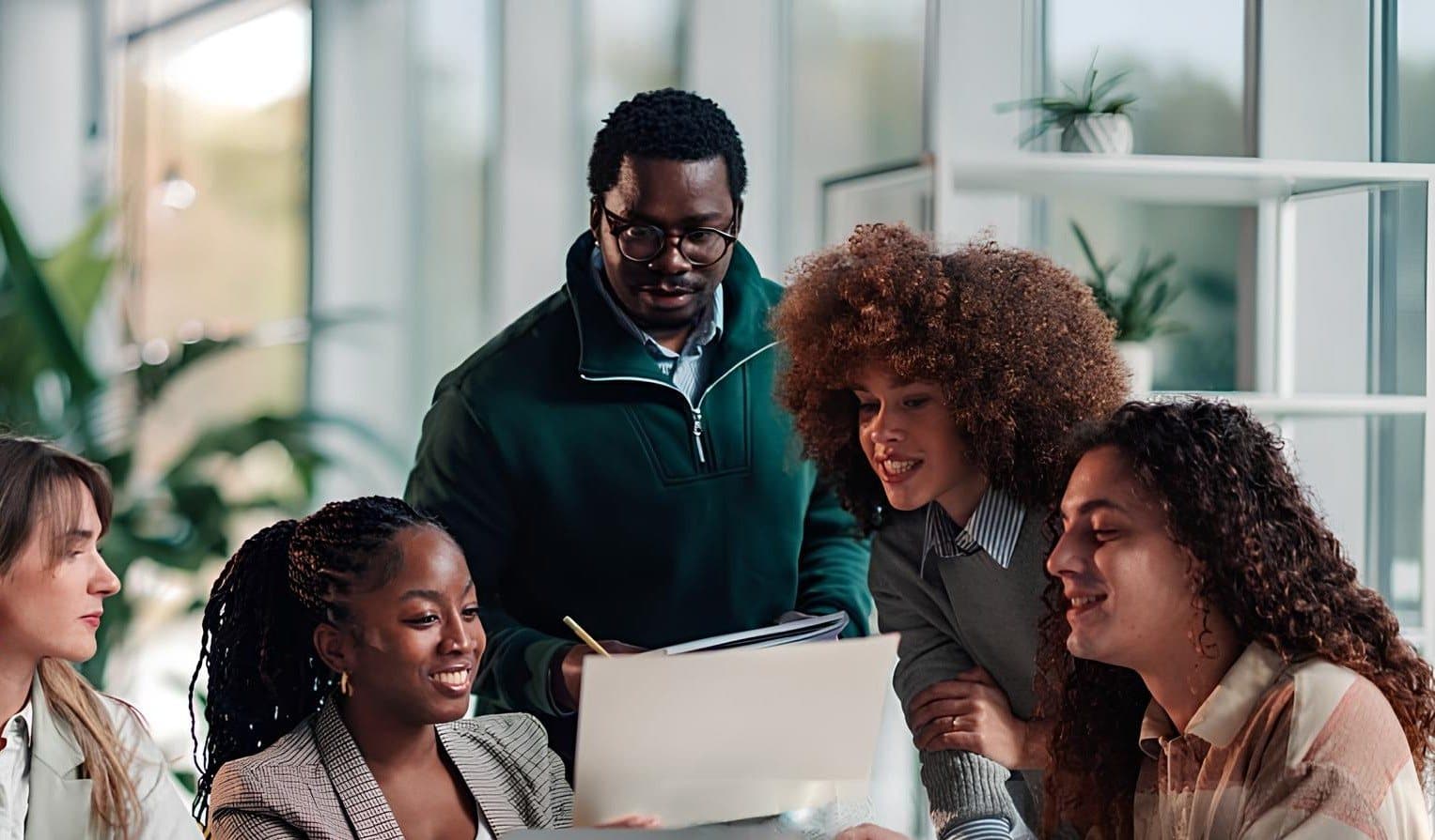 A team collaborating around a laptop